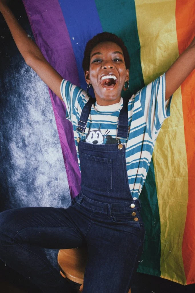 Personne en salopette, portant un drapeau LGBT - image choisie par Benoit Monchotte, psy à Lyon, psychopraticien LGBT+